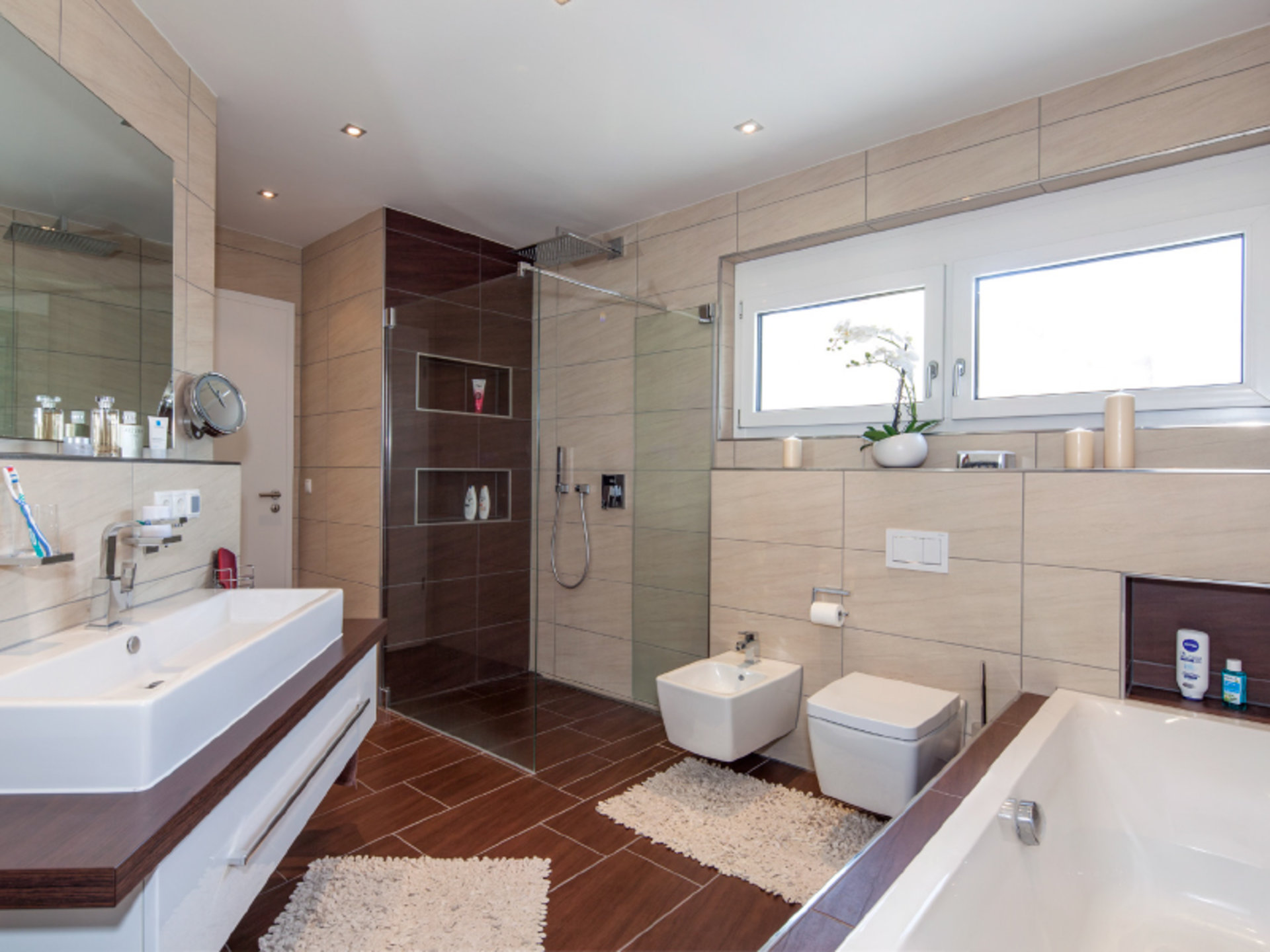 Haus Fuchs – Badezimmer in warmer Holzoptik mit bodengleicher Dusche (Foto: BAUMEISTER-HAUS)